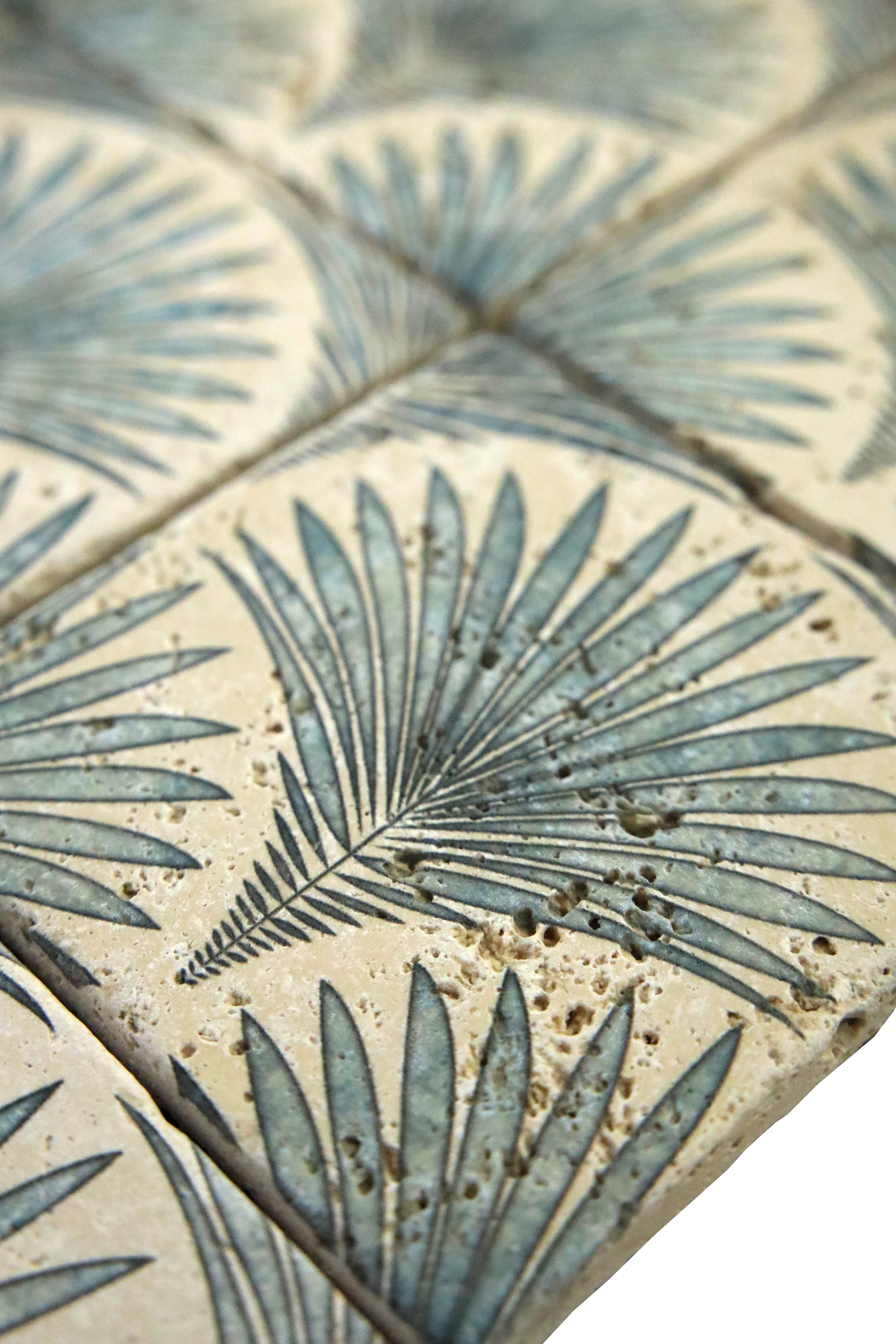Close-up of Scallop Travertine Venato tile showing decorative botanical detailing on travertine stone