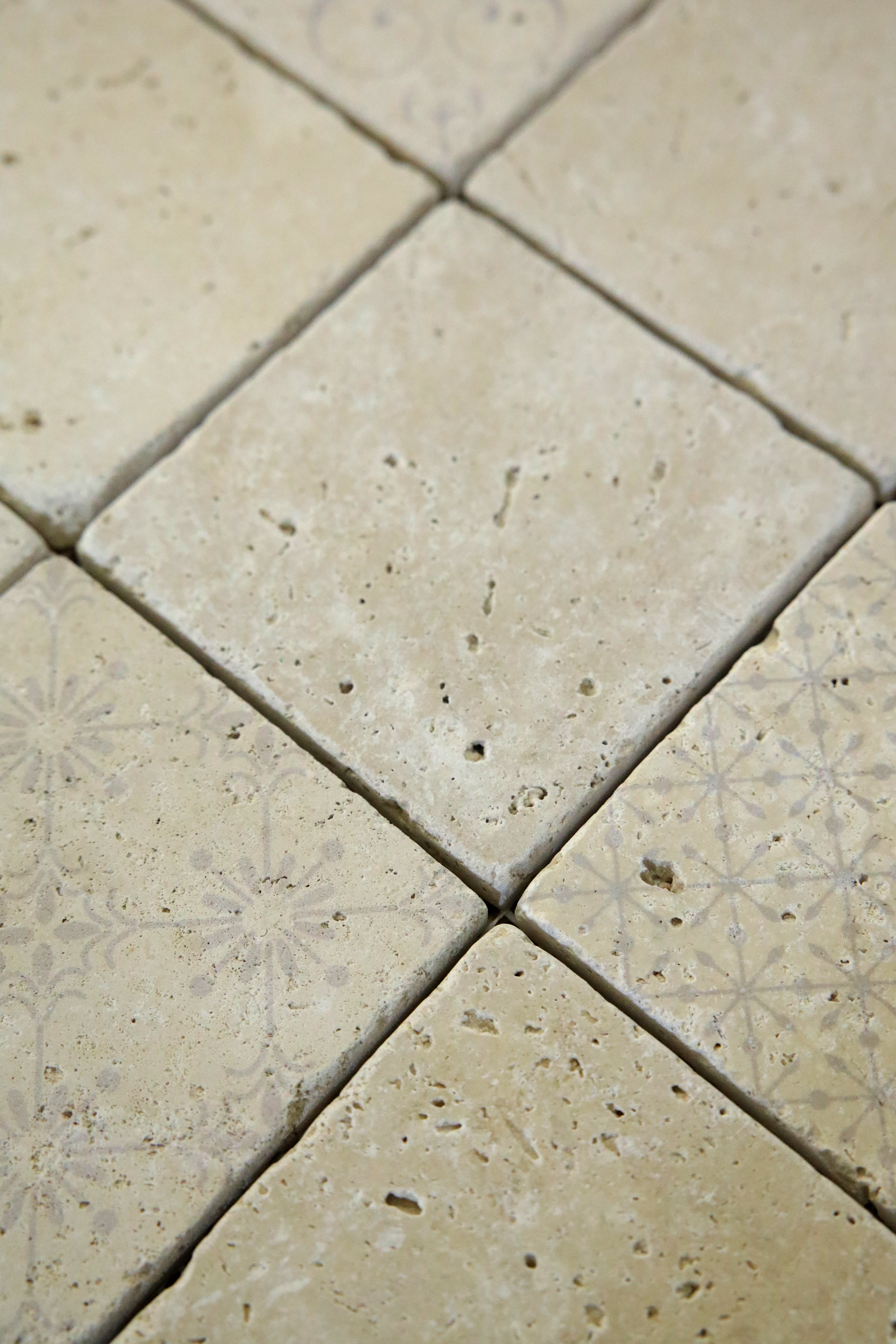Decorative ivory travertine mosaic tile with subtle vintage-inspired patterns